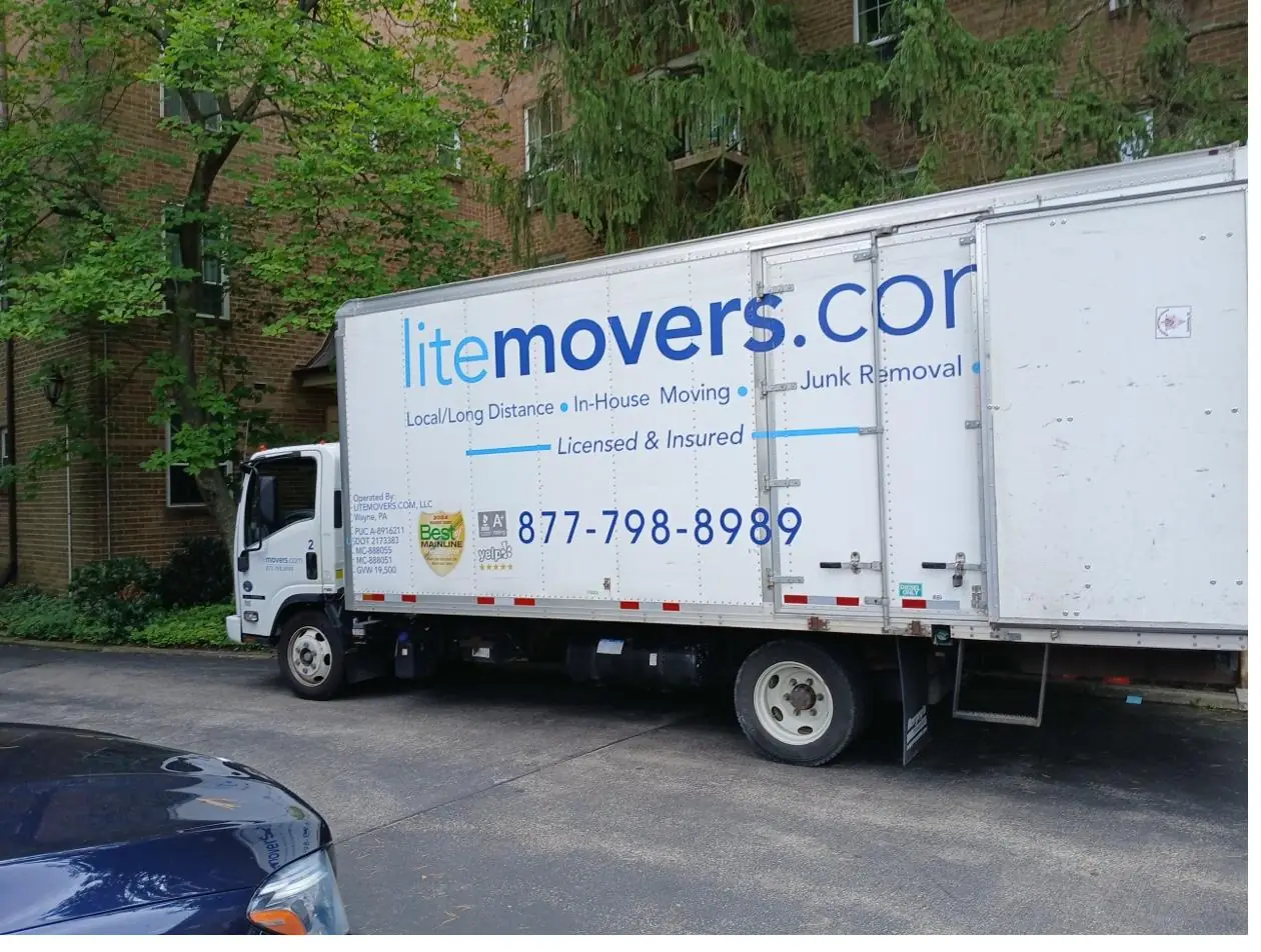 LiteMovers truck parked at the entrance of a brick apartment complex