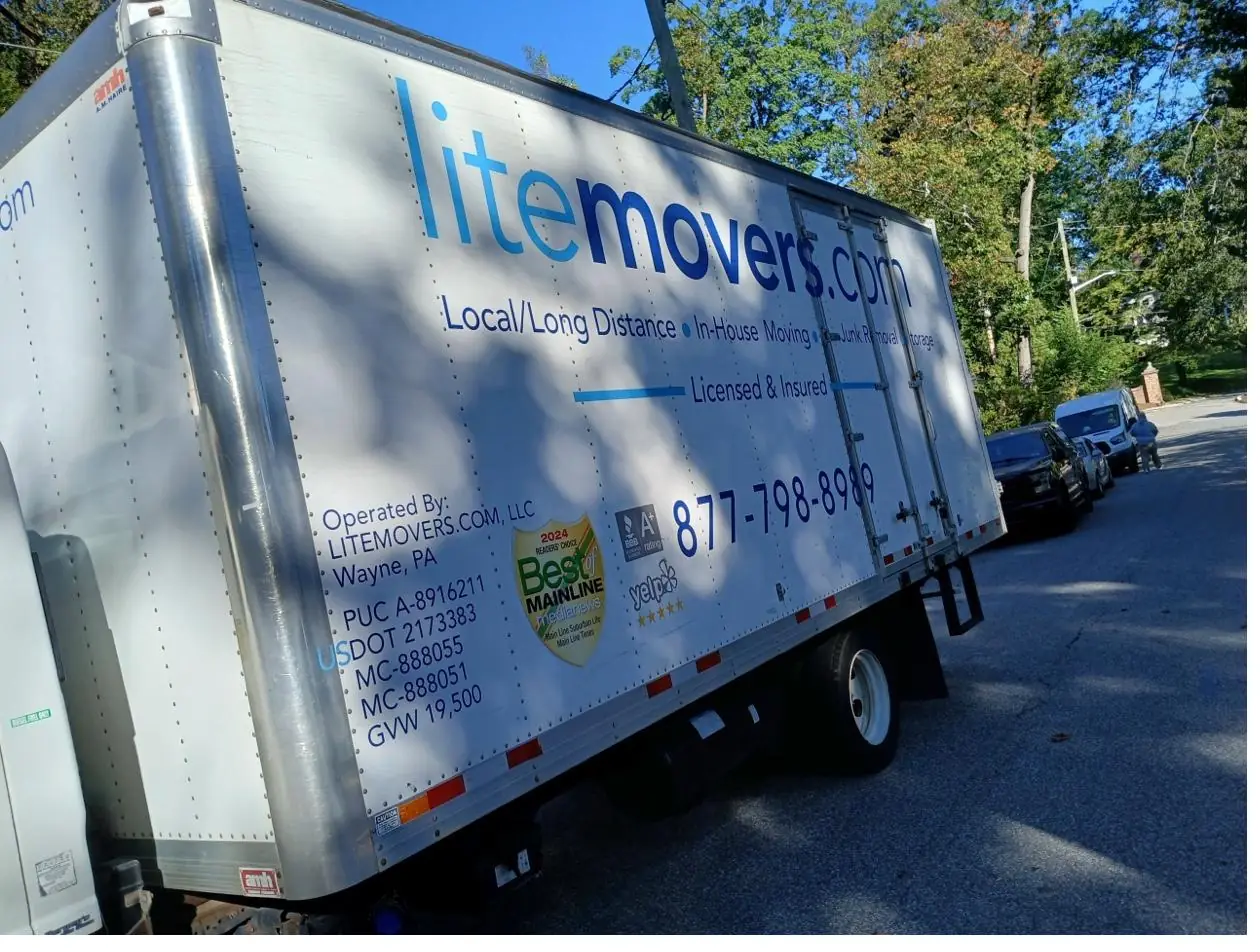 Side of a LiteMovers truck showing PUC A-8916211, USDOT 2173383, MC-888055 and Best of Main Line badge
