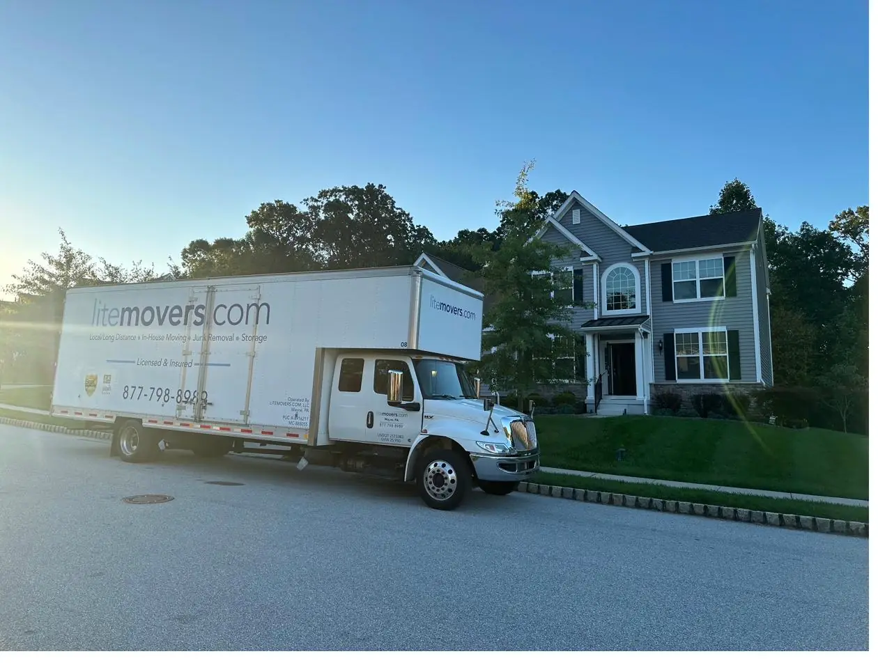 LiteMovers truck parked in front of a two-story suburban home at dusk